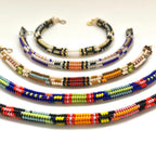 Five beaded bracelets arranged in a fan shape on a plain white background, each featuring different colorful bead patterns.